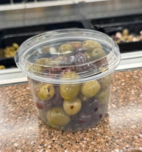 olives in a plastic food package with a lid that doesn't fit