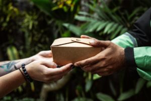 a person handing a box to another person 