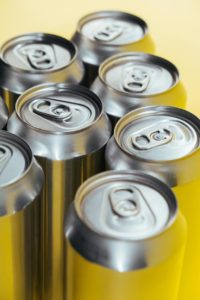 Several cans of soda Photo by cottonbro studio: https://www.pexels.com/photo/silver-cans-in-close-up-photography-5538240/