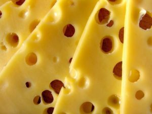 Close-up of slices of cheese Photo by Leandro Bezerra: https://www.pexels.com/photo/cheese-on-shelf-in-market-8542326/