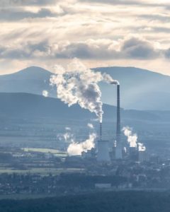 Smoke stacks of smoke coming out of a factory picture: https://pixabay.com/users/rzierik-16088724/
