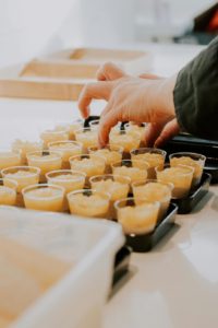 someone touching food samples: Photo by Léo Gilmant: https://www.pexels.com/photo/shots-with-ice-on-a-tray-25539489/