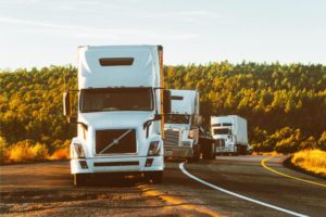 trucks on a road. Photo by Quintin Gellar: https://www.pexels.com/photo/white-volvo-semi-truck-on-side-of-road-2199293/