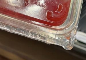 Leaking plastic container of watermelon