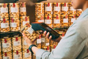 someone scanning a can of nuts. Photo by iMin Technology: https://www.pexels.com/photo/person-scanning-qr-code-on-jar-of-pickles-12935049/