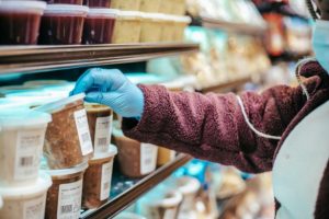 someone stacking soup containers on a shelf. Photo by Laura James: https://www.pexels.com/photo/woman-choosing-frozen-product-in-supermarket-6097890/