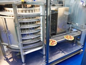 Pizzas entering a spiral freezer